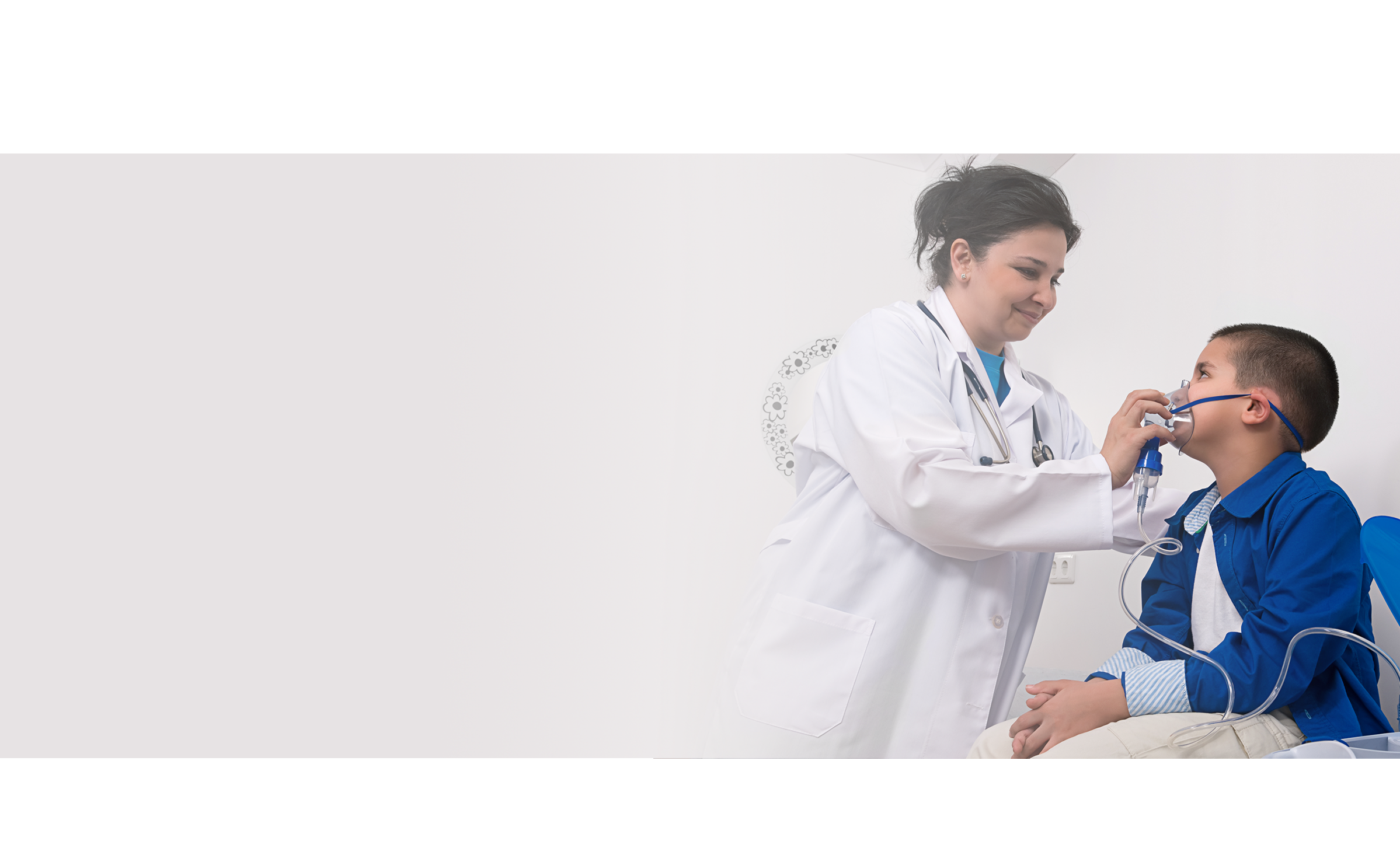 Pediatra y linda niña con inhalador en la clínica